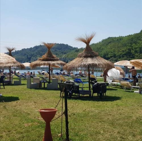 - un groupe de chaises longues et de parasols sur une plage dans l'établissement Appartamento vicino ai laghi e Aereoporto di malpensa, à Cassano Magnago
