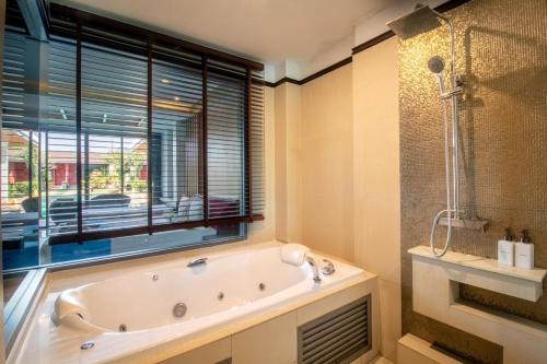 baño con bañera y ventana en Mai Morn Resort SHA Plus en Phuket