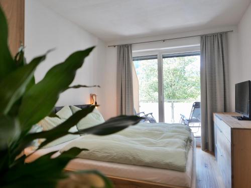 ein Schlafzimmer mit einem Bett und einem großen Fenster in der Unterkunft Apartment Auszeit in Gröbming