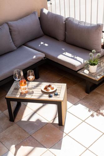 un canapé et une table avec deux verres de vin dans l'établissement La Maison Mentone Lorgues, à Lorgues