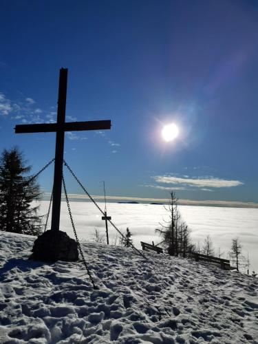 a cross on top of a snow covered hill at Troadkasten - Ferienhaus am BIO-Bergbauernhof in Aflenz Kurort