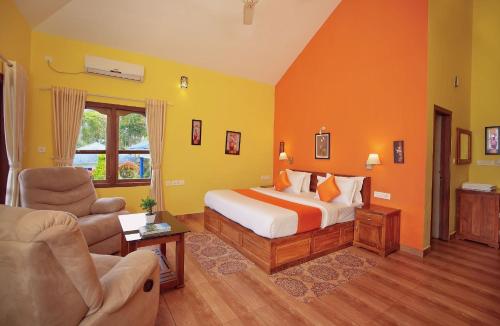 a bedroom with a bed and a couch and a chair at Zenha Resorts in Munnar