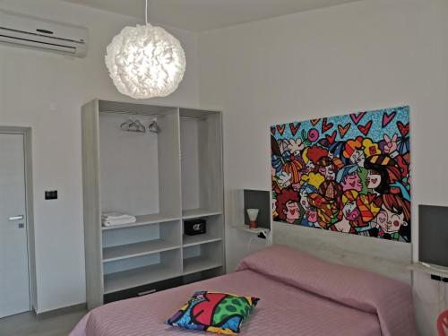 Un dormitorio con una cama rosa y una pintura en la pared. en Wonderland en San Teodoro