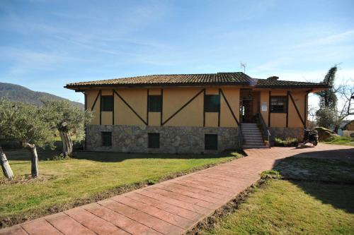 a house with a brick walkway in front of it at Hotel Rural Hosteria Fontivieja TR-CC-195 in Losar de la Vera