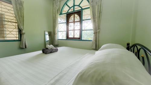 Un dormitorio con una gran cama blanca y una ventana en Karon house 15A, en Karon Beach