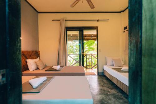 a room with two beds and a window with a view at Himaya in General Luna