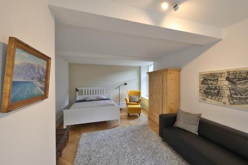 a living room with a bed and a couch at City Center Apartment in Interlaken