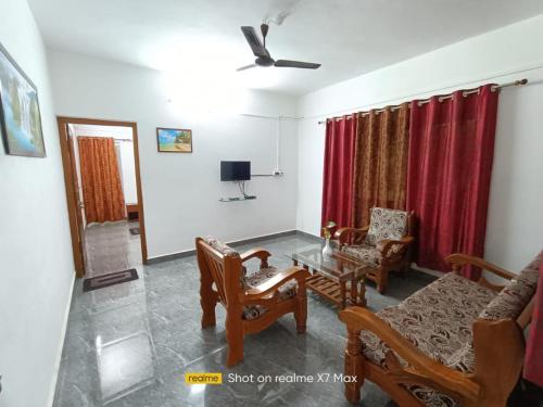 a living room with a table and chairs and a tv at Palolem Sunrise Apartment in Palolem