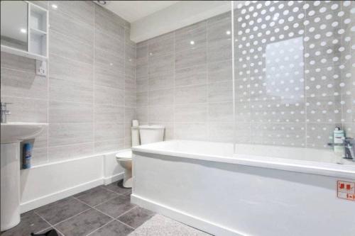y baño con bañera, aseo y lavamanos. en Cozy 4 Bed Flat in Islington London, en Londres