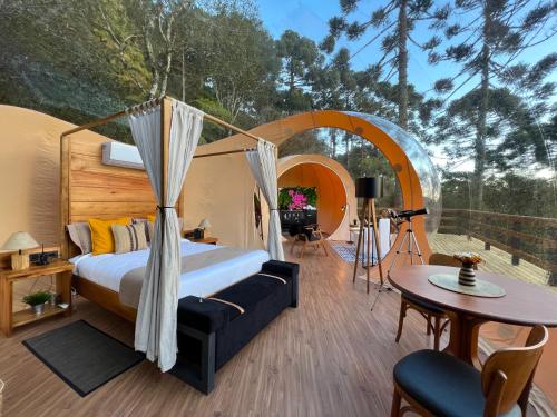 ein Schlafzimmer in einem Zelt mit einem Bett und einem Tisch in der Unterkunft Zion Bubble Glamping in Urubici
