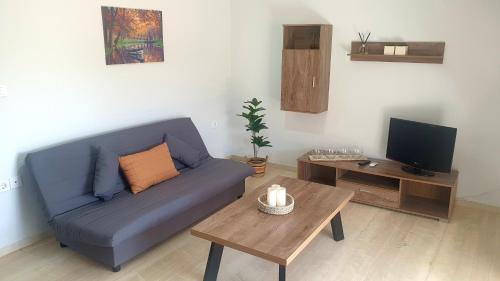 ein Wohnzimmer mit einem blauen Sofa und einem Couchtisch in der Unterkunft Christy's House Anavissos / Ανάβυσσος in Anavyssos