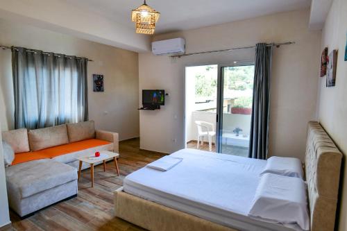 a living room with a bed and a couch at Joyous Apartments in Sarandë