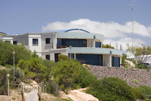 una casa blanca en la cima de una colina rocosa en Cliff House Beachfront Villas en Moonta