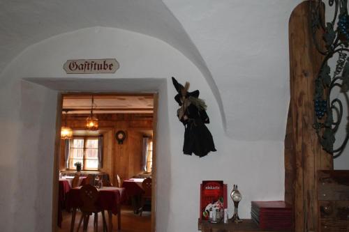 a dining room with a table and a black dress hanging on the wall at Gasthof zur Traube in Pettneu am Arlberg