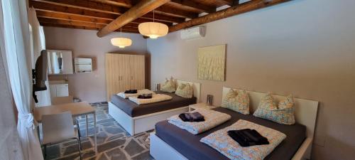 Cette chambre comprend deux lits, une table et un canapé. dans l'établissement Casa Romantica, à Colico