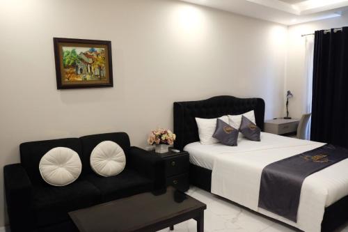 a bedroom with two beds and a couch at Aisha HOTELS and APARTMENTS in Hanoi