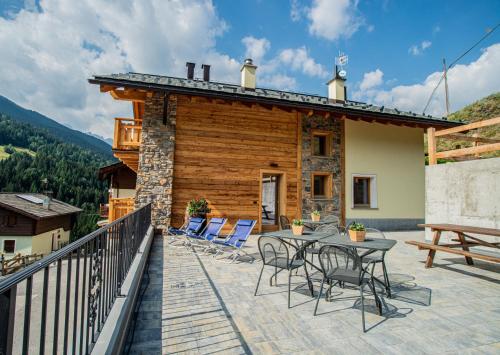 a house with a deck with chairs and a table at Pradella Apartments in Valdidentro