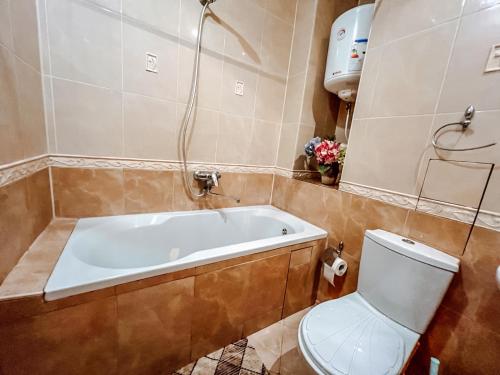 La salle de bains est pourvue d'une baignoire et de toilettes. dans l'établissement Cozy apartments on the Left Bank, à Kiev