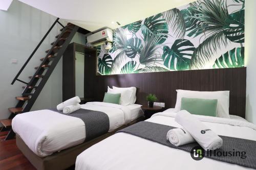 duas camas num quarto com um mural na parede em Trevor Hotel Malacca Town By I Housing em Malaca