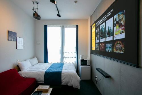 ein Schlafzimmer mit einem Bett und einem großen Bildschirm in der Unterkunft Theatel Haneda Ⅱ in Tokio