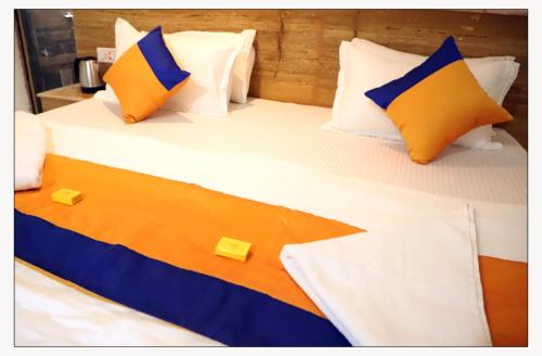 a bed with two yellow and blue pillows on it at Jaisalmer Desert Resort in Jaisalmer
