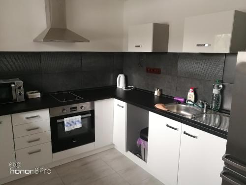 a kitchen with white cabinets and a black counter top at Ubytování Záluží in Kozlovice