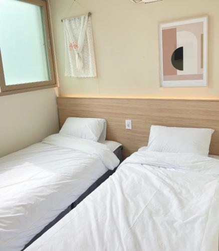 two beds sitting next to each other in a room at Well Plus Guest House in Seoul