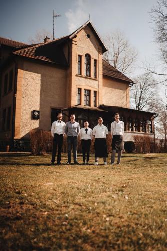 a group of men standing in front of a house at Pałac Poraj in Wicko