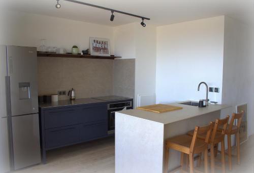 a kitchen with a counter and a sink and a refrigerator at Apartment design calme garage piscine vue exceptionnelle in Saint-Laurent-du-Var