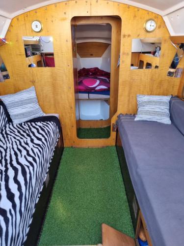 2 camas en una habitación pequeña con alfombra verde en VOILIER AU SOLEIL LEVANT, en Le Havre