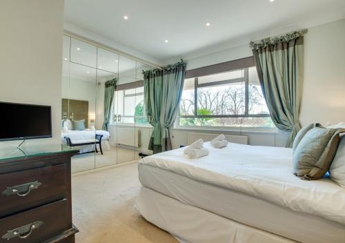 een slaapkamer met een groot bed en een spiegel bij La Villa in Rottingdean