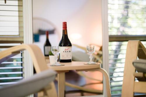 - deux bouteilles de vin assises sur une table avec des verres dans l'établissement Shambala Eco Retreat, à Mount Tamborine