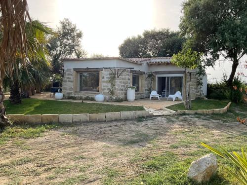 a stone house with two chairs in a yard at Mazet du pêcheur in Saint-Laurent-dʼAigouze
