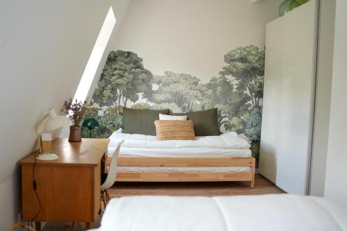 een slaapkamer met 2 bedden en een muurschildering bij Les Hirondelles, gîte de charme avec jardin, 7p in Saint-Valery-sur-Somme