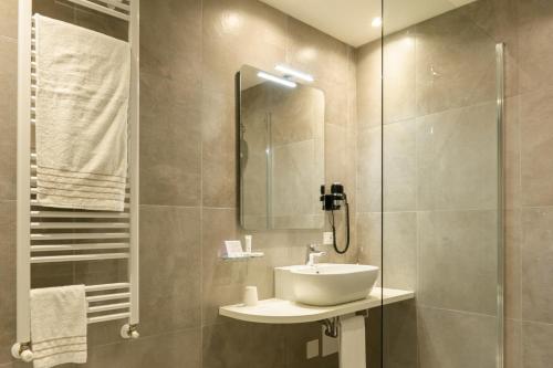 a bathroom with a sink and a glass shower at Hotel Globo in Formigine