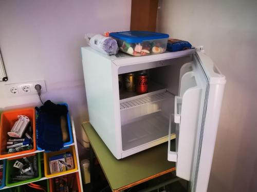 a small white refrigerator with its door open at La Casa de los Pájaros in Vélez Blanco