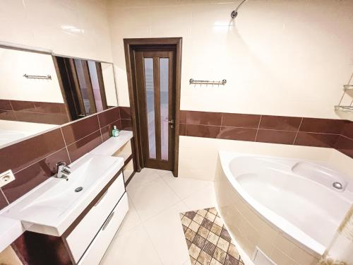 a bathroom with a tub and a sink and a bath tub at Cozy apartments on the Left Bank in Kyiv