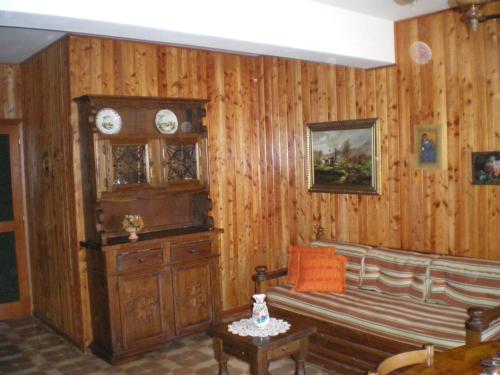 a living room with wooden walls and a bench and a clock at Residence I Comignoli in Scanno