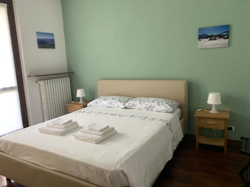 een slaapkamer met een bed met handdoeken erop bij Appartamento rosada in Stresa