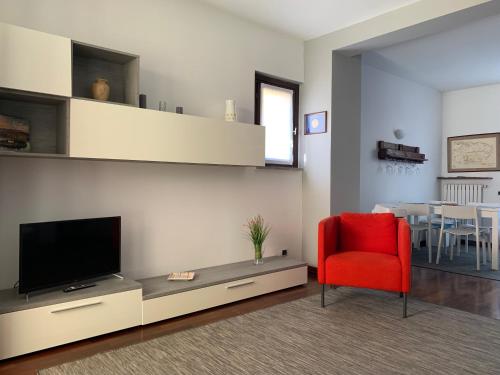 a living room with a red chair and a television at Appartamento rosada in Stresa