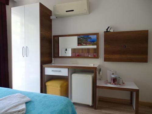 1 dormitorio con escritorio, mesa y cama en Arikanda River Garden Hotel, en Adrasan