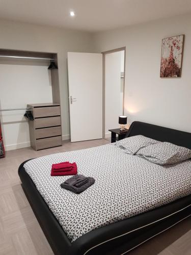 Un dormitorio con una cama con una maleta roja. en Appartement centre ville, en Moulins