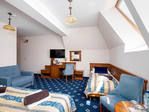 a attic room with two beds and a desk at Hotel Liptakówka in Białka Tatrzanska