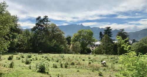 a field with a house in the background with mountains at Studio 329 in Aix-les-Bains