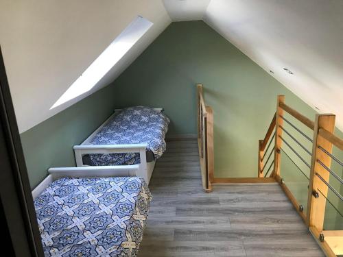 a attic room with two bunk beds and a staircase at Gîte spa sauna piscine in Aubin-Saint-Vaast