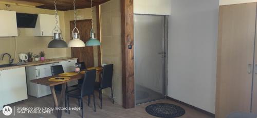 une cuisine avec une table et une porte en verre dans l'établissement Apartament Good Night, à Nowy Dwór Gdański
