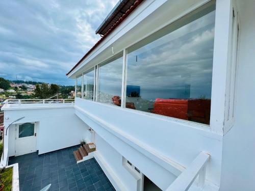 a balcony with views of the ocean from a house at M town Homestay in Kodaikānāl