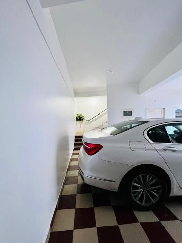 a white car parked in a room with a checkered floor at M town Homestay in Kodaikānāl