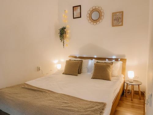 a bedroom with a bed with white sheets and pillows at Cozy 2-Bedroom Boho-Themed Home in Caransebeş