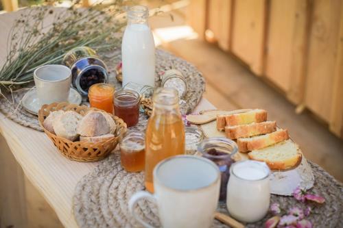 einen Tisch mit Brot und Flaschen Milch und Getränke in der Unterkunft Au coeur de nos bois in Battut